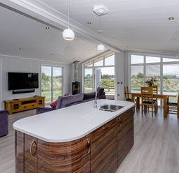 A living room with a kitchen island and dining area at Wordsworth in Wigton