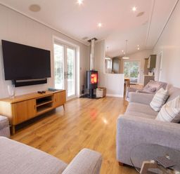 A living room with a television and wood stove at Lawson in Wigton