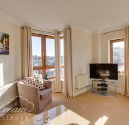 A living room with a sofa and television at Harbourside Apartment in Weymouth