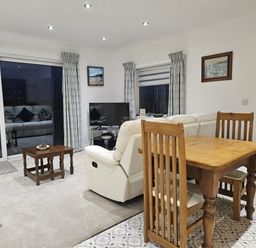 A living room with a sofa and a table at Ty Nain in Bethel