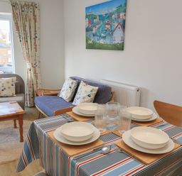 A dining room with a table set for meals at Brewery View in Weymouth