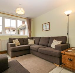 A living room with a sofa and television at Dovecote Cottage Corse near Gloucester