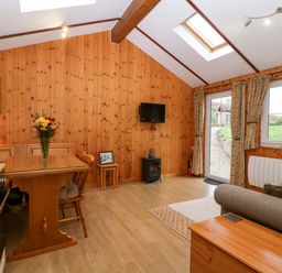 A living room featuring a dining table and chairs at The Log Cabin in Corse near Gloucester