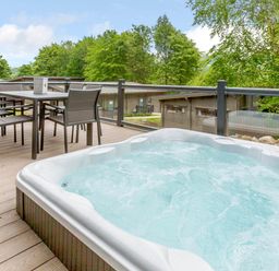 An outdoor area with a hot tub and dining table at Wensleydale Aysgarth