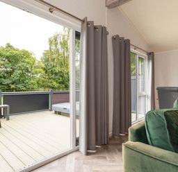 A living room with doors leading to a deck at Wensleydale in Aysgarth