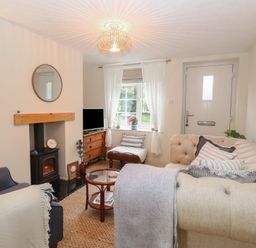 A living room with a sofa and a television at Beeble Cottage in Fakenham