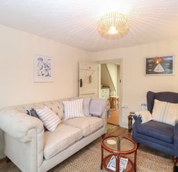 A living room with a sofa and armchair at Beeble Cottage in Fakenham