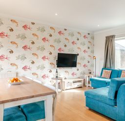 A living room with a table and sofa at Summerleaze Cottage 2 Spa Bude