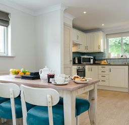 A kitchen with dining table and chairs at Summerleaze Cottage 2 Spa in Bude