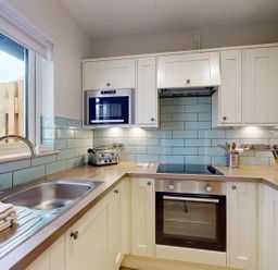 A kitchen with sink, oven, and microwave at Summerleaze Cottage 2 Spa Bude
