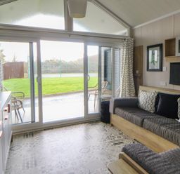 A living room with a sofa and television at The Family Pod in Swansea