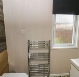 A bathroom with a window and towel rail at The Family Pod in Swansea
