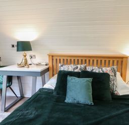 A bedroom with a bed and bedside table at Garden Lodge 1 Swansea