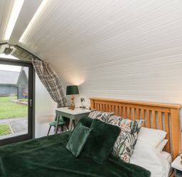A bedroom with a bed and a table at Garden Lodge 1 Swansea