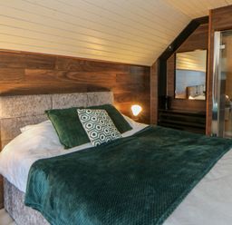 A bedroom with a bed and attached bathroom at Garden lodge 3 Swansea
