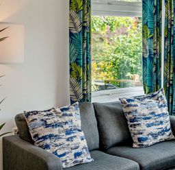 A living room with a sofa and cushions at Kernow Nook Spa Perranporth