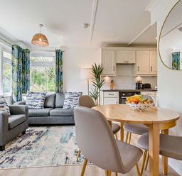 A living room with a sofa and dining table at Kernow Nook Spa, Perranporth