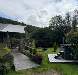 An outdoor area with a tent, deck, hot tub and furniture at Ceri in Newcastle Emlyn