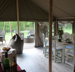 A dining area with a table and chairs in a tent at Ceri Newcastle Emlyn