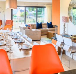 A living room with a dining table and sofa at Nan's House Spa in Marhamchurch