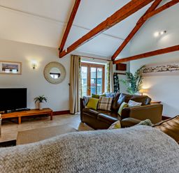 A living room with a sofa and television at Barley Park in Marhamchurch