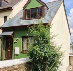 A house with a green wall and brown door at The Gables in Teignmouth