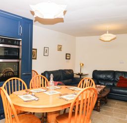A kitchen with dining table and sofa at The Gables in Teignmouth
