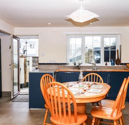 A kitchen with a table and chairs at The Gables in Teignmouth