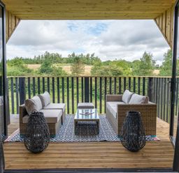 An outdoor living area with sofa and table at Orka 1.0 Spa (Pet) Dumfries