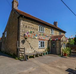 An exterior view of The Trooper Inn with seating outside at The Old Barn in Stourton Caundle near Stalbridge