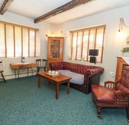 A living room with a sofa and table at The Old Barn in Stourton Caundle near Stalbridge