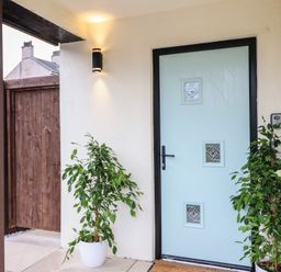 An entrance area with a blue door and plants at Pistyll Ddu in Brynsiencyn near Llanfairpwllgwyngyll