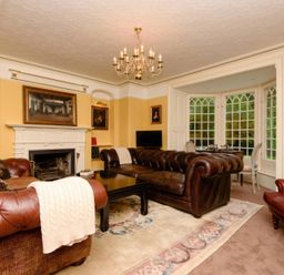 A living room with a fireplace and sofas at Ladye Park in Liskeard