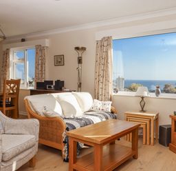 A living room with a sofa and dining area at Woodbury in Teignmouth