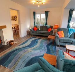 A living room with a fireplace and sofas at Westerlodge in Threlkeld near Keswick