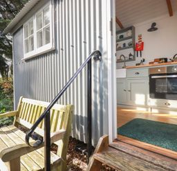 A kitchen with a door and window leading to the outside at Hillbre Shepherd Hut, Padstow