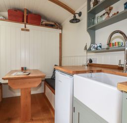 A kitchen with a table and sink at Hillbre Shepherd Hut in Padstow