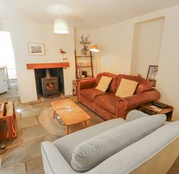 A living room with a sofa and a fireplace at Rock Cottage in Milnthorpe