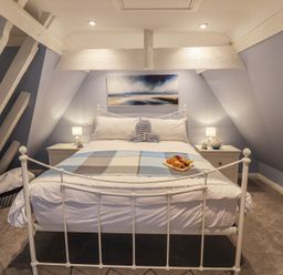 A bedroom with a bed and bedside tables at The Nutshell in Aldeburgh