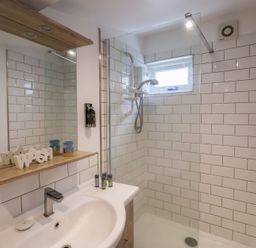 A bathroom with a shower and sink at The Nutshell in Aldeburgh