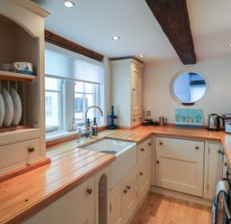 A kitchen with a sink and cooking area at The Nutshell in Aldeburgh