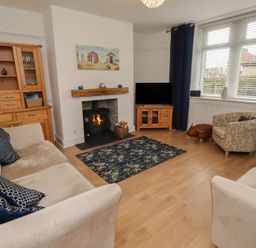 A living room with a sofa and armchair at 23 Northumbria Terrace Amble