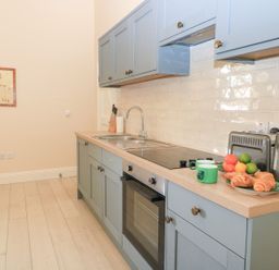 A kitchen with cabinets and appliances at Woodcock Studio Andoversford near Cheltenham