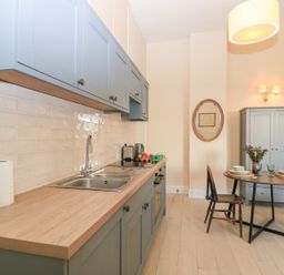A kitchen with cabinets and dining space at Woodcock Studio in Andoversford near Cheltenham