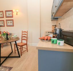 A kitchen with a table and chairs at Swallow Studio in Andoversford near Cheltenham