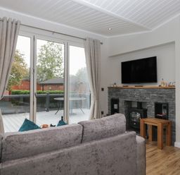 A living room with a sofa and television at 7 Lake View in Windermere