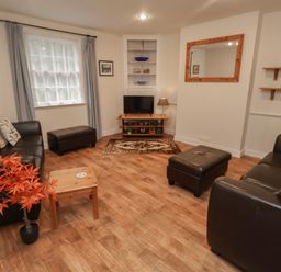 A living room with a sofa and coffee table at Duke Cottage in Woodbridge