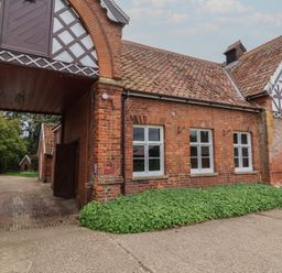 An outdoor view of a brick building with arched entrance at Duchess Cottage in Woodbridge
