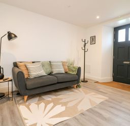 A living room with a sofa and a coat rack at Klysa in Camborne