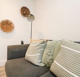 A sofa with cushions and wall decor at Klysa in Camborne
